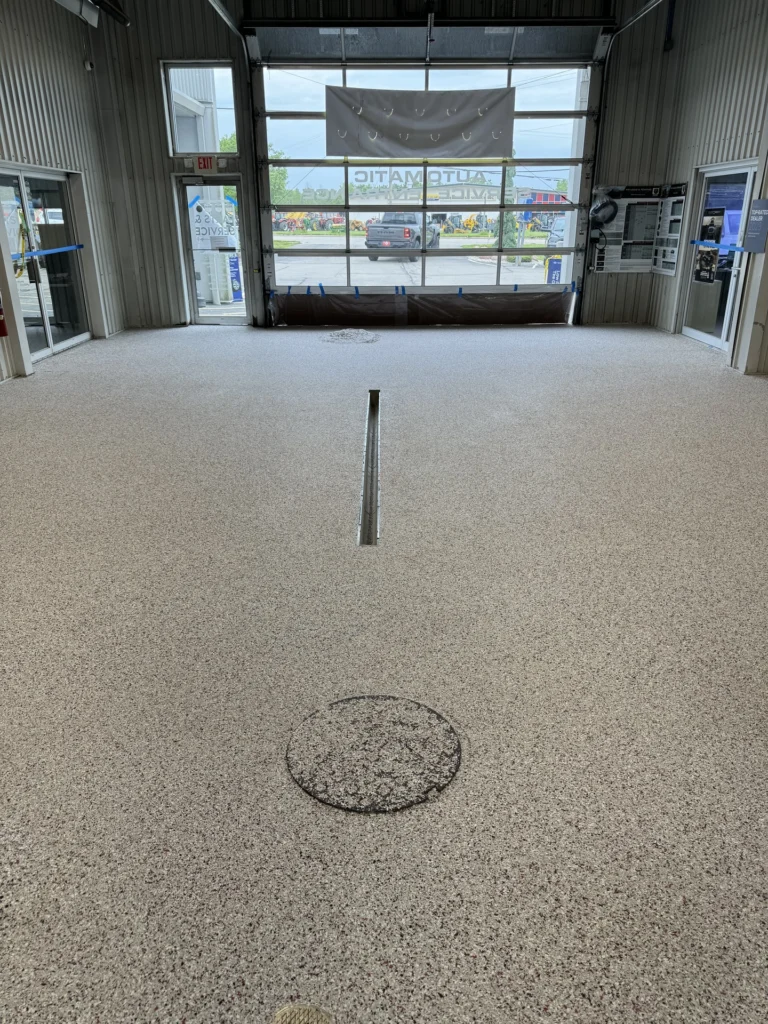 Commercial garage interior with durable floor coating and repaired crack, featuring a smooth, light gray finish.