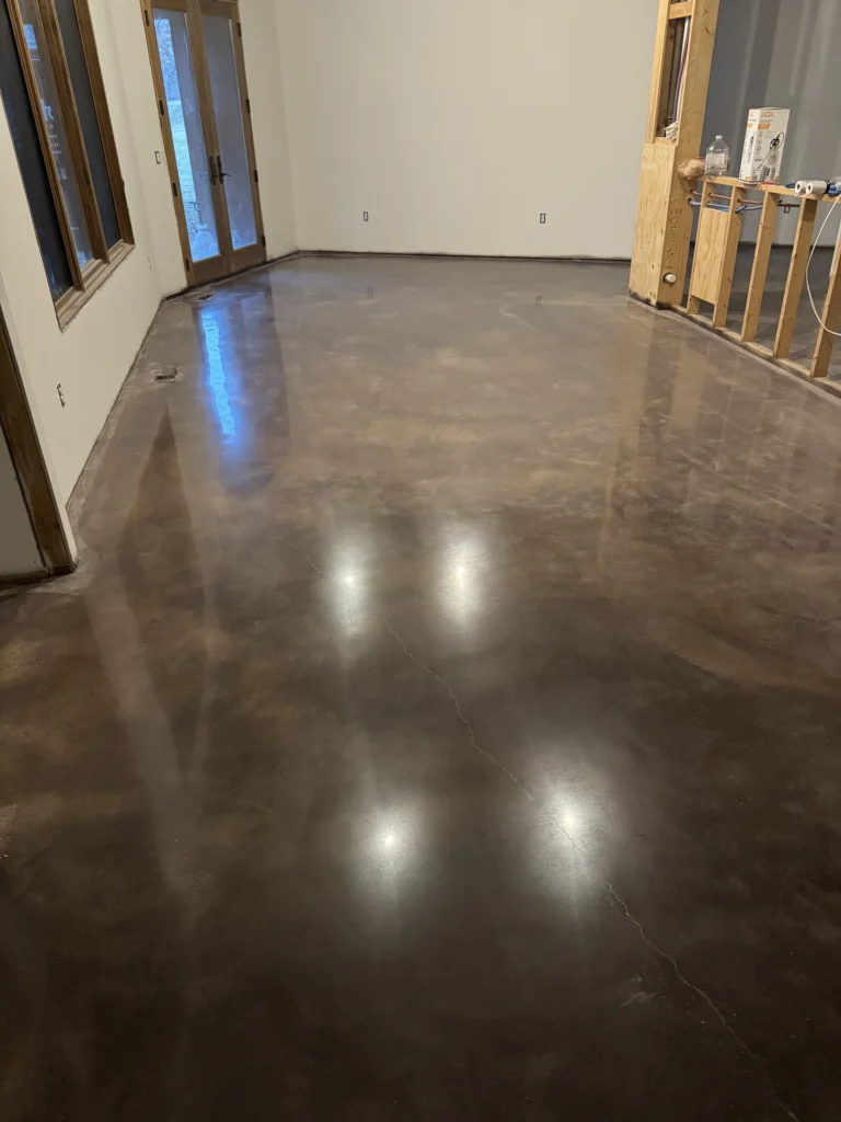 Polished dark gray concrete floor in an empty room with reflective shine and smooth surface texture