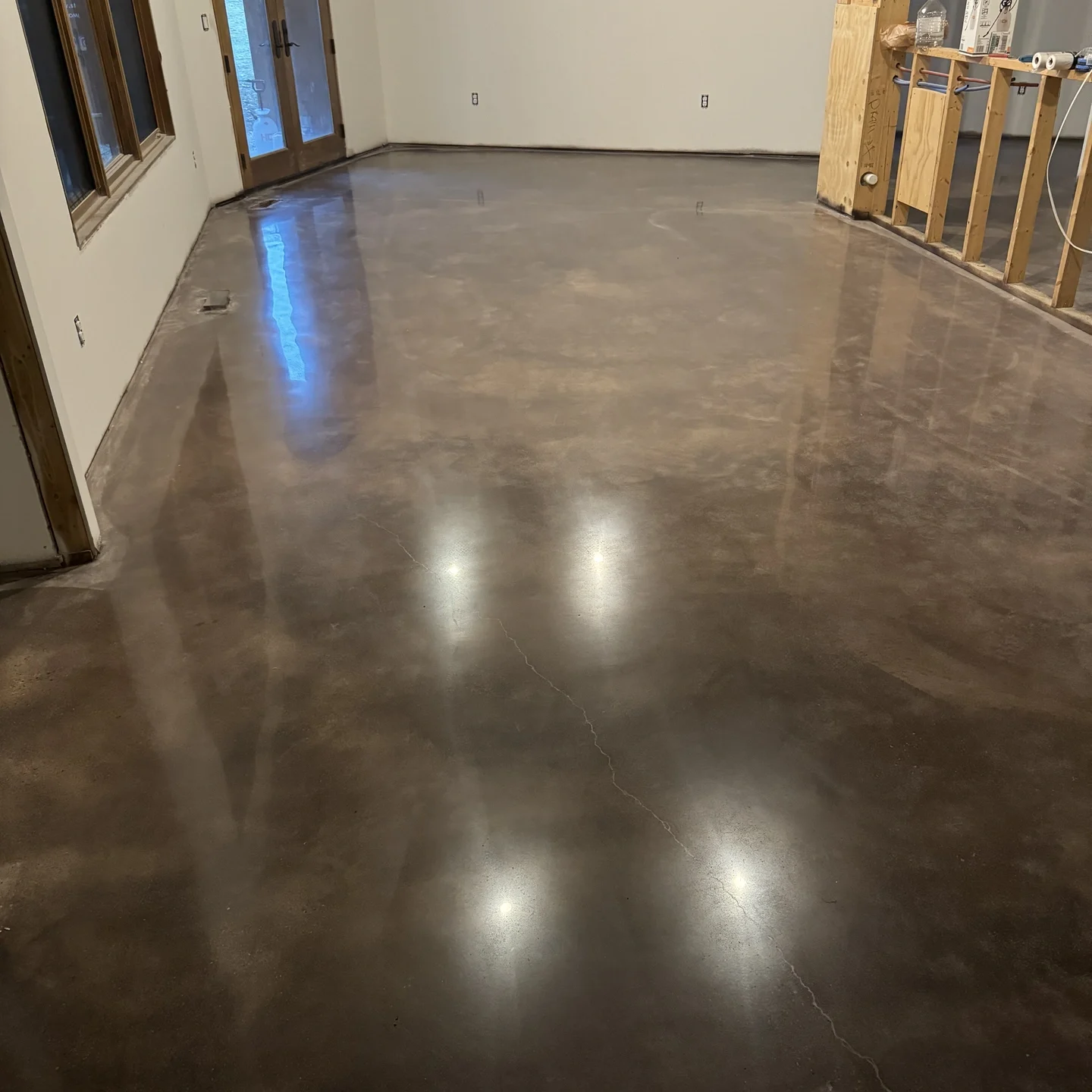 Polished dark gray concrete floor in an empty room with reflective shine and smooth surface texture