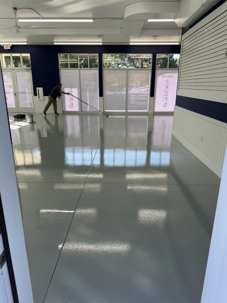 Employee cleaning and maintaining a reflective gym floor with interior glass windows