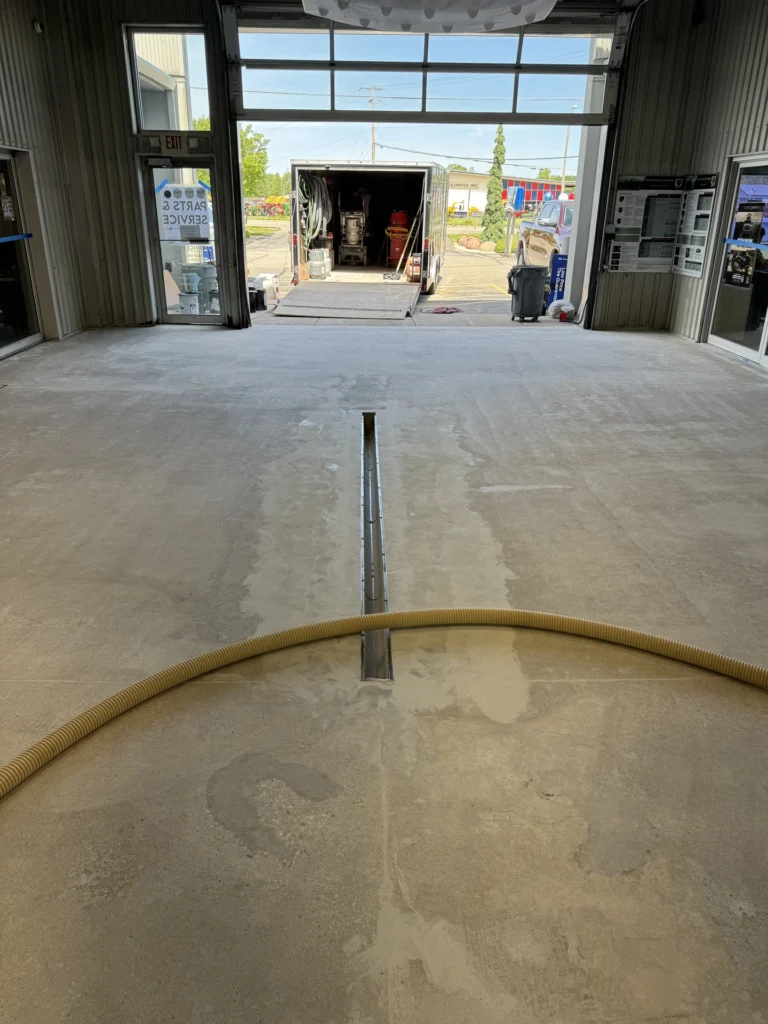 View from inside an industrial workshop with concrete floor being repaired and coated with a durable resinous coating