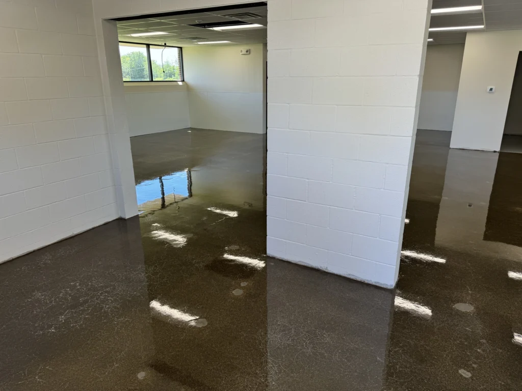 Polished concrete flooring in an empty office space with natural light coming through the windows